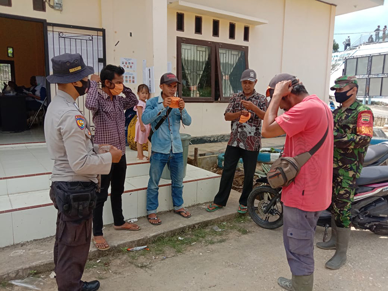 Polsek Langgam bersama TNI Bagikan Masker kepada Masyarakat di Posko Covid-19