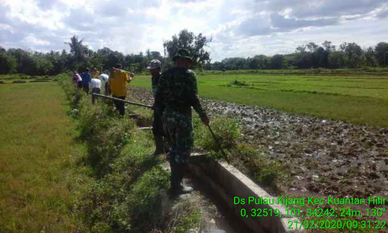 Babinsa Koramil 07/Kuantan Hilir Dim 0302/Inhu, Serda Sadali Gotong Royong Membersihkan Saluran Irigasi Bersama Masyarakat Pulau Kijang.