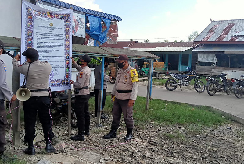 Personel Polsek Kuala Kampar Laksanakan Giat Sosialisasi dan Pasang Spanduk Terkait Prokes 
