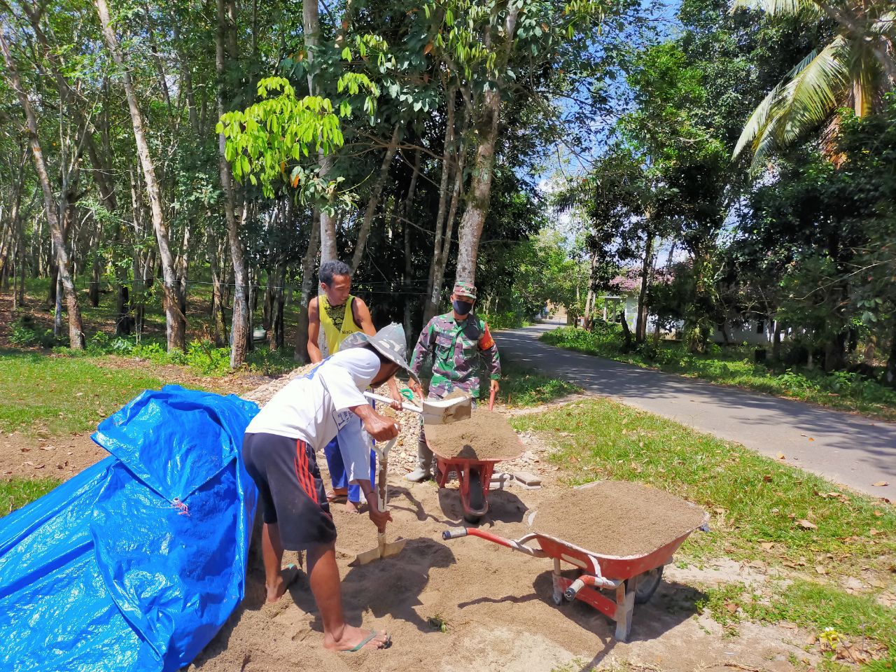 Sertu Parman Anggota Koramil 07/Kuantan Hilir Dim 0302/Inhu Goro Semenisasi Jalan Di Desa Danau