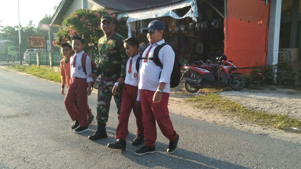 Anggota Koramil Cerenti Koptu Juanda,Bimbing Anak SD Menyebrang Jalan Raya.