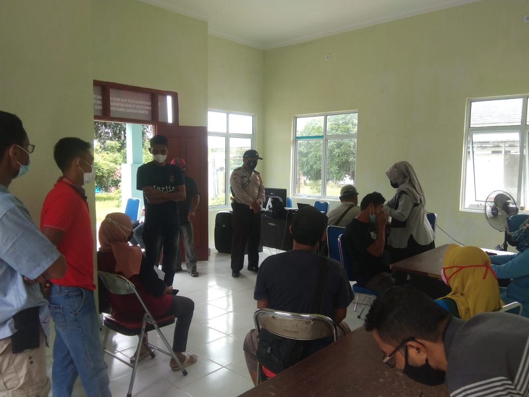 Bhabinkamtibmas Polsek Kerumutan Dampingi Vaksinasi Warga di Puskesmas Cinta