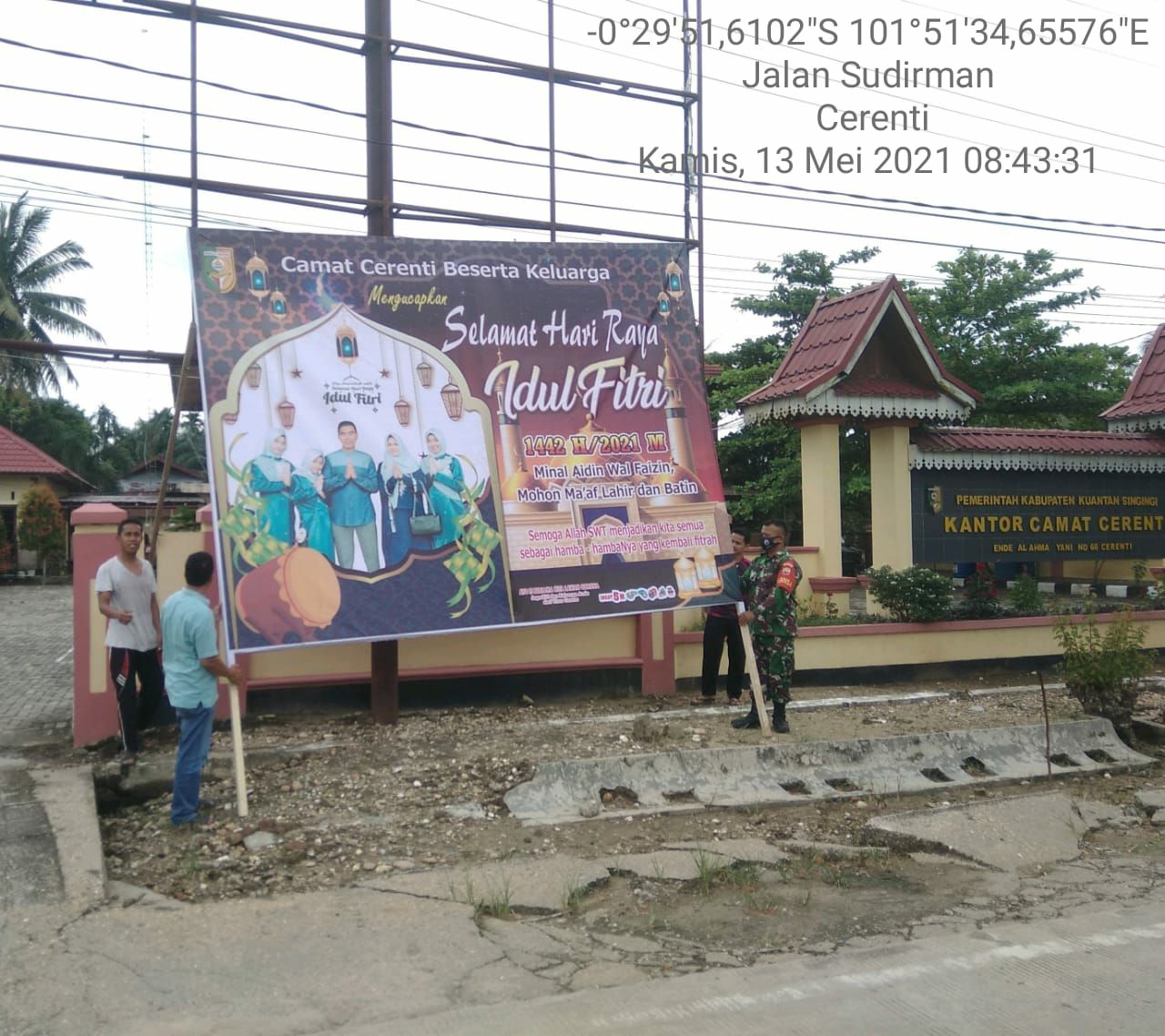 Babinsa Bantu Perangkat Kecamatan Dirikan Baleho Didepan Kantor Camat