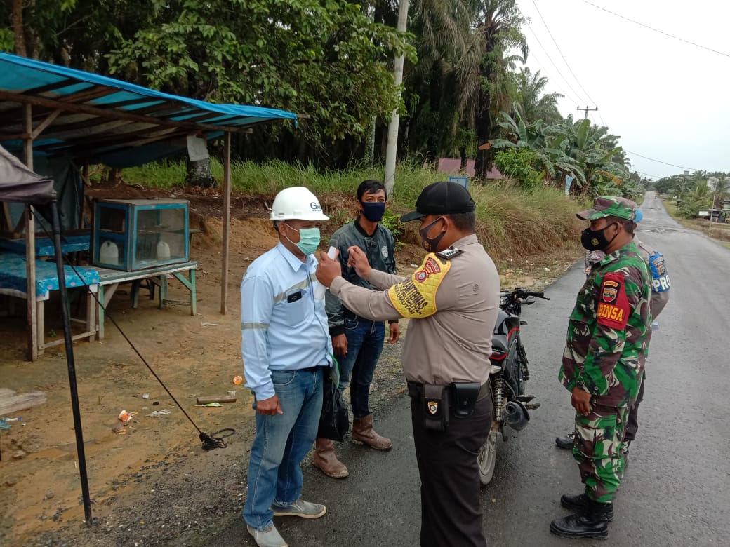 Bhabinkamtibmas Polsek Kerumutan Gelar Imabuan Prokes dan Bagikan Masker di Pos PPKM