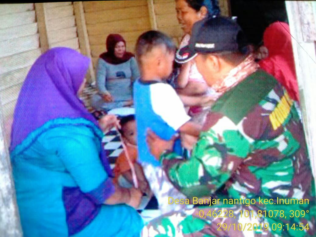 Sertu Heriyus Saputera Bersama Bidan Desa Melakukan Imunisasi Kepada Balita.
