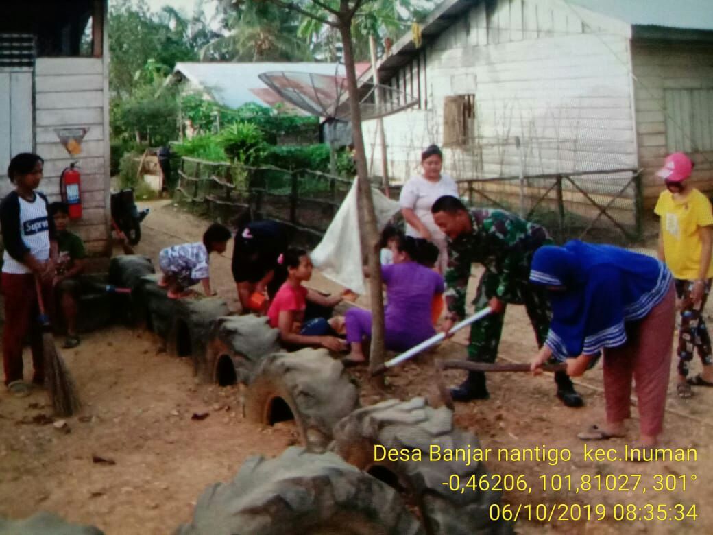 Sertu Heriyus Gotong Royong Membersihkan Kantor Desa.