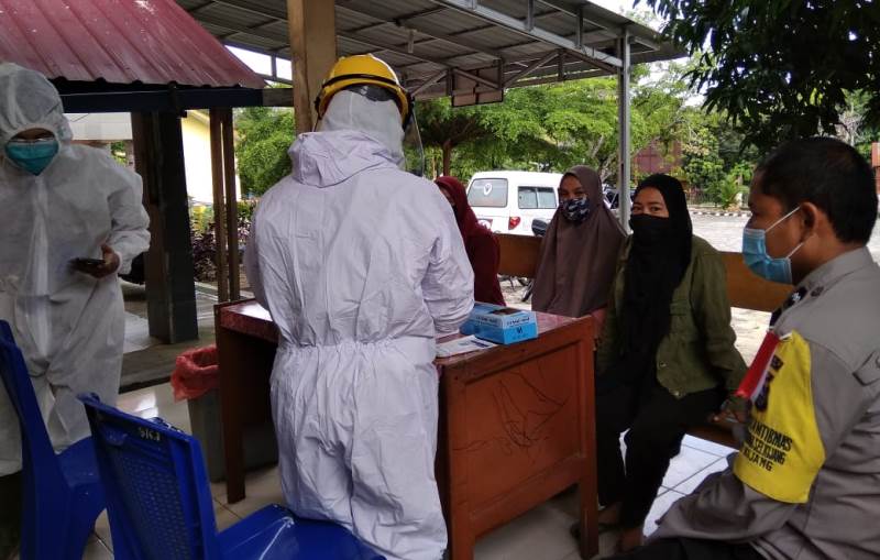 Personel Polsek Bandar Sei Kijang Dampingi Petugas Kesehatan Lakukan Pemeriksaan Rapid Test