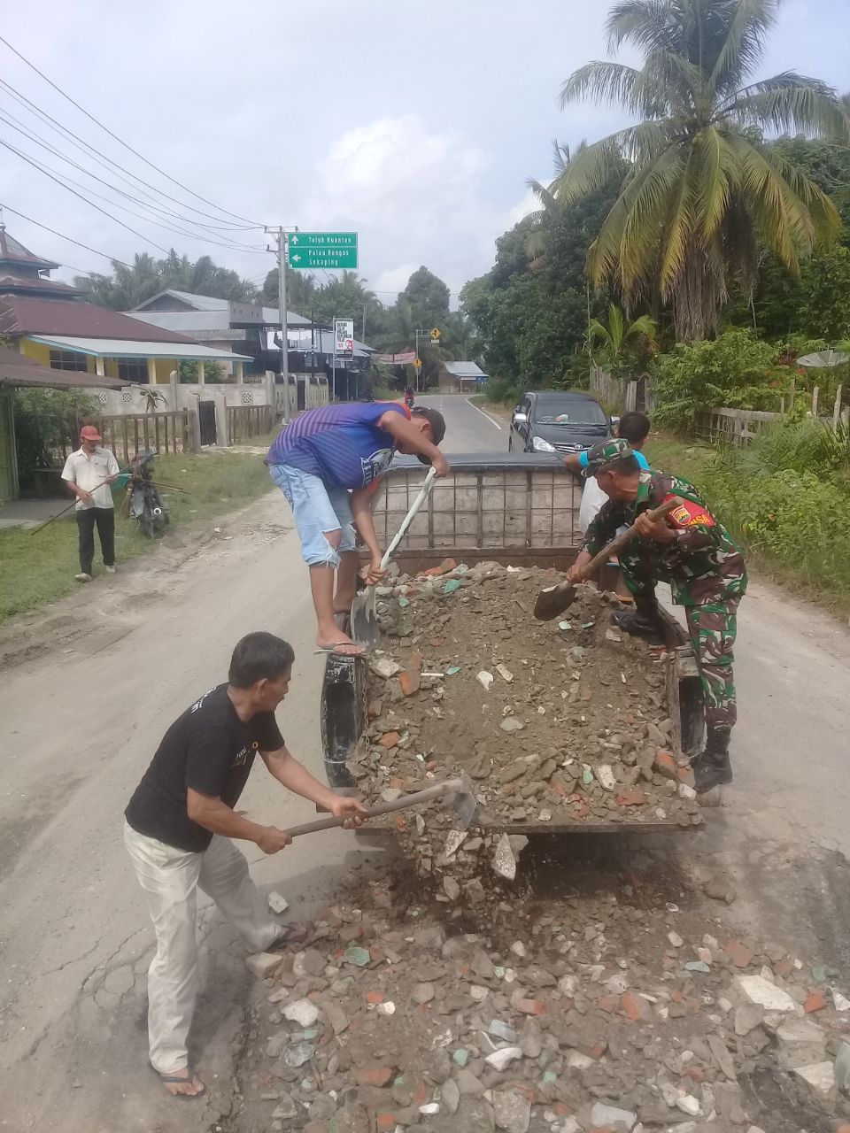Serma Mulyadi Anggota Koramil 07/Kuantan Hilir Dim 0302/Inhu Gotong Royong Menimbun Jalan Berlobang.