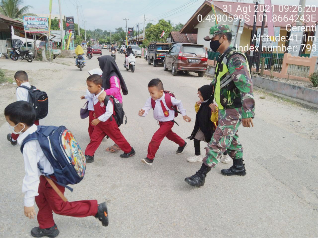 Kopda Junedi Babinsa Koramil 06/Cerenti Kodim 0302/Inhu Bantu Seberangkan Anak Sekolah Dasar Kelurahan Koto Peraku