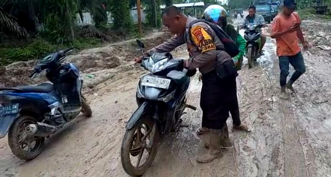 Sesuai Perintah Kapolres Bengkalis, Bhabinkamtibmas Bantu Warga Lalui Jalan Rusak