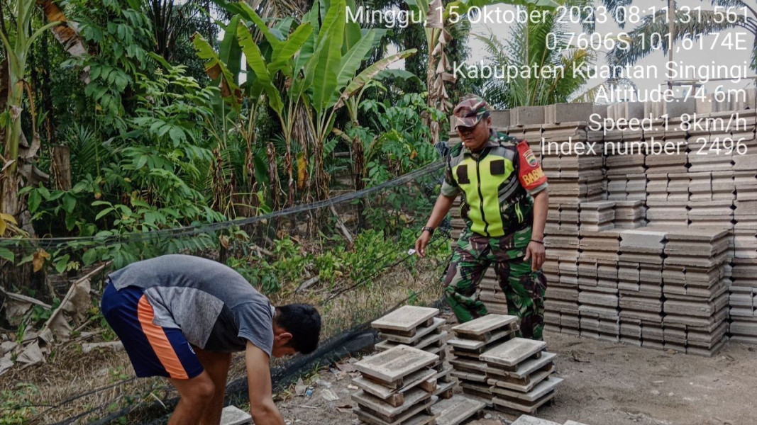 Anggota Koramil 06/Cerenti Kodim 0302/Inhu Serka Heriyus Saputera  Membantu Warga  Mengangkat Batako