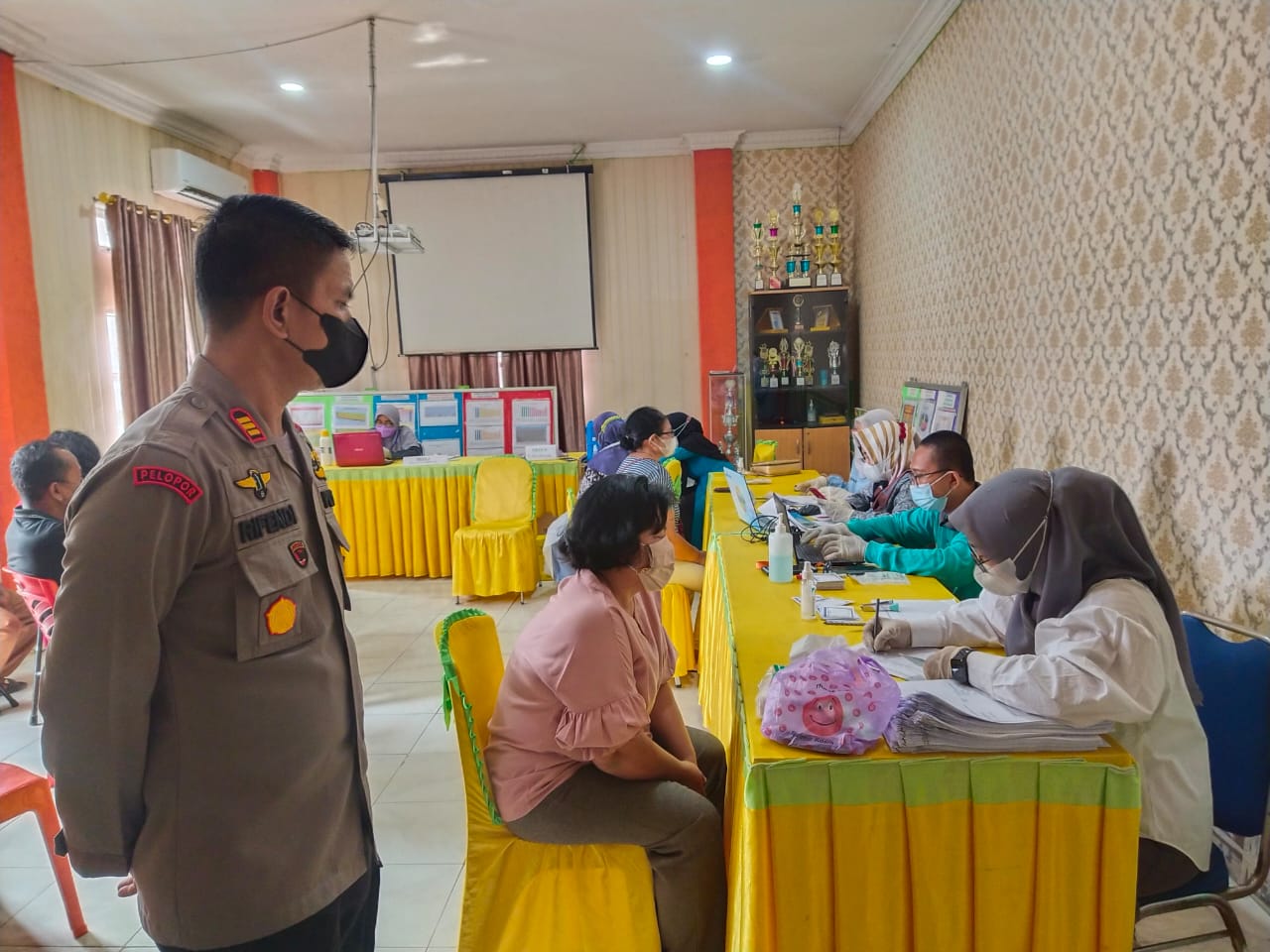 Kapolsek Ukui Kembali Dampingi Warga Jalani Vaksinasi di Kelurahan Ukui