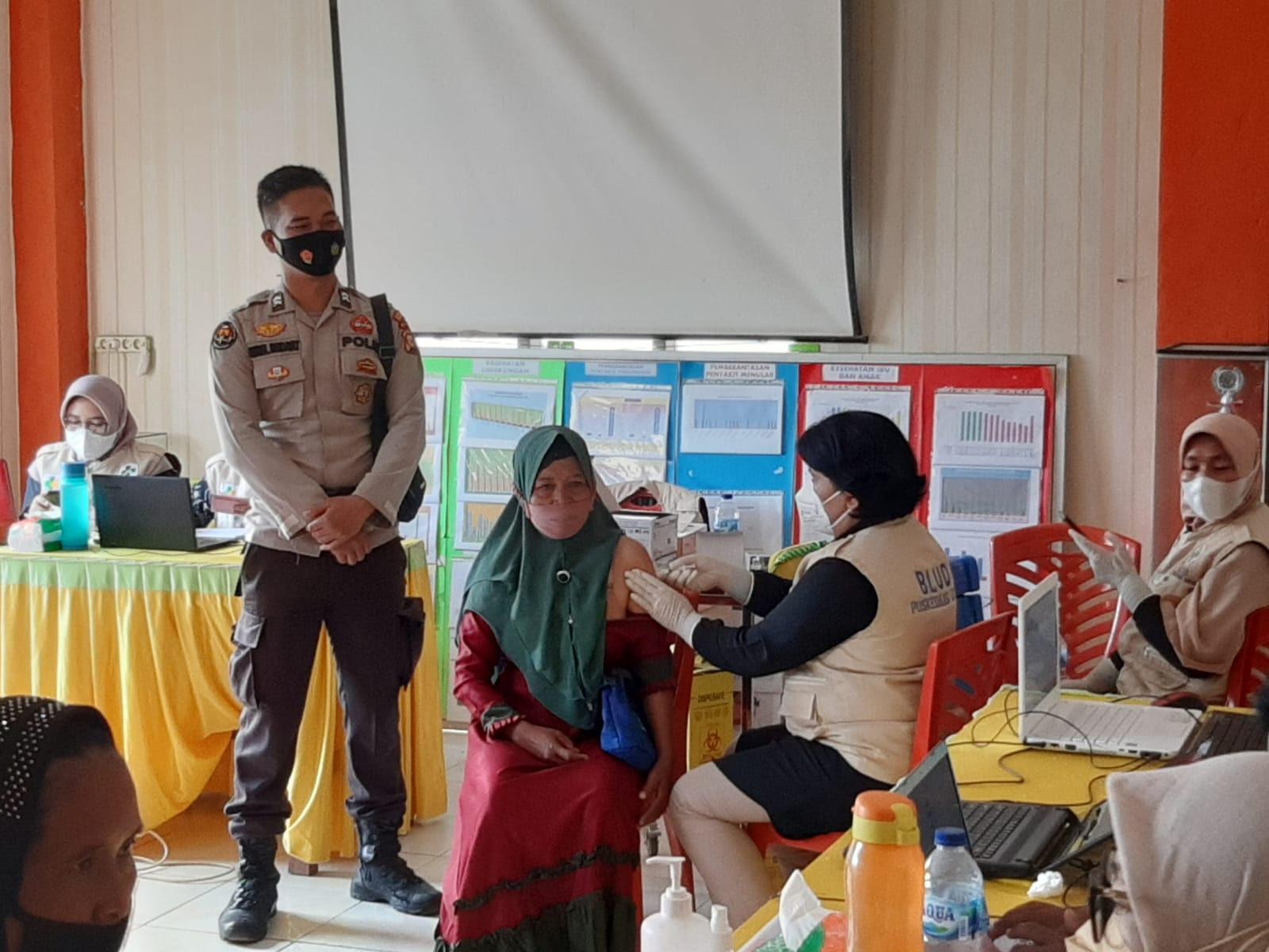 Personel Polsek Ukui Amankan Pelaksanaan Vaksinasi Dosis I di Puskesmas