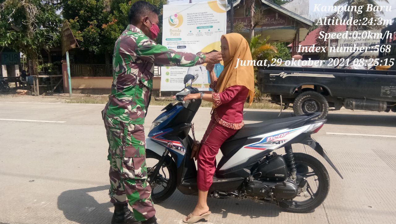 Babinsa Koramil 06/Cerenti Kodim 0302/Inhu Di Jalan Raya Dengan Hadang Pengendara Sepeda Motor Bagikan Masker
