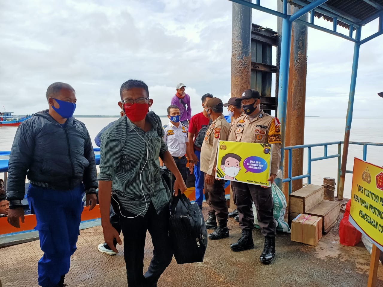 Personel Polsek Kuala Kampar Imbau Warga di Pelabuhan Gunakan Masker