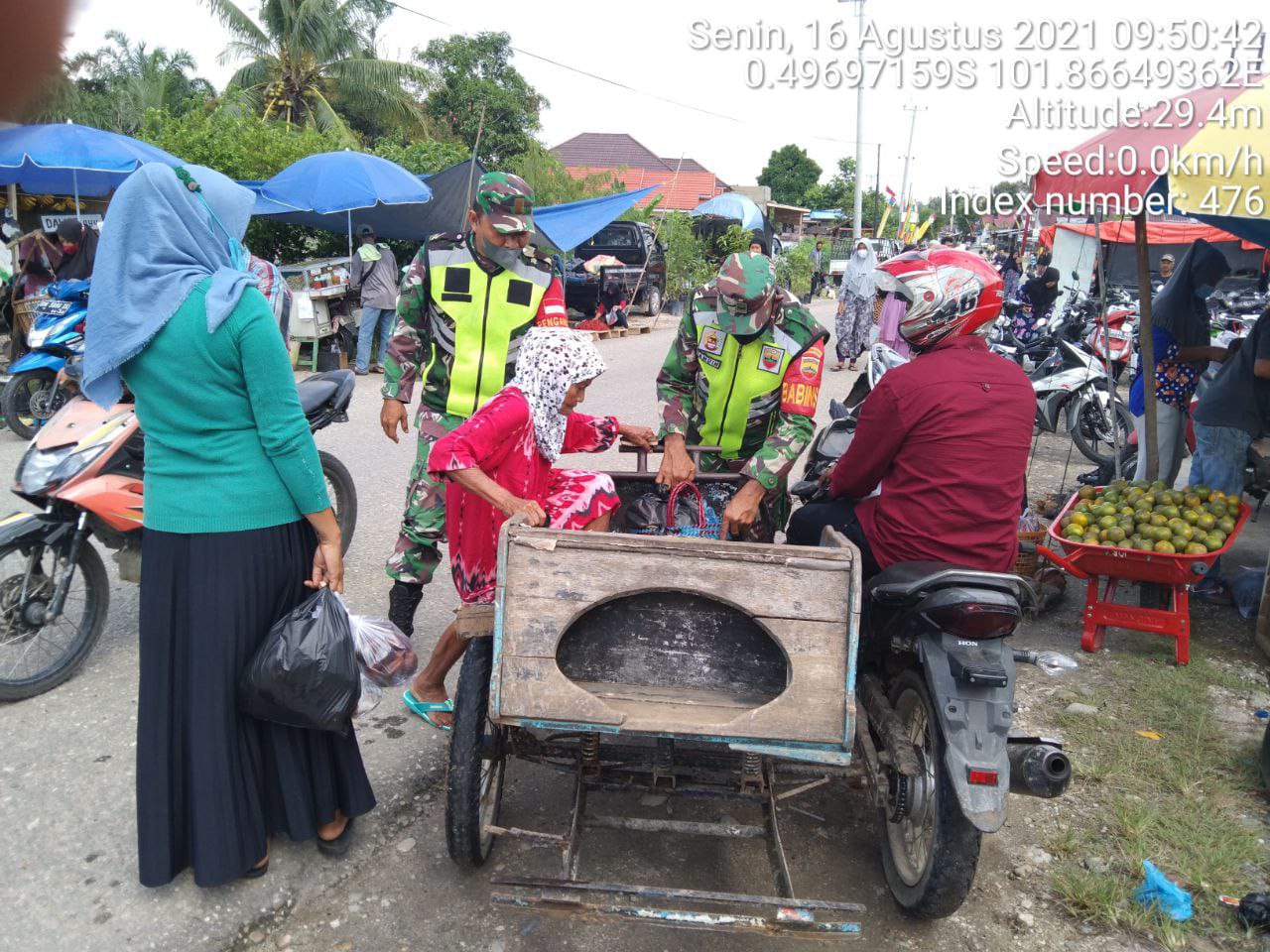 Babinsa Koramil 06/Cerenti Kodim 0302/Inhu Bantu Angkat Barang Belanjaan Nenek ke Atas Becak di Pasar Tradisional