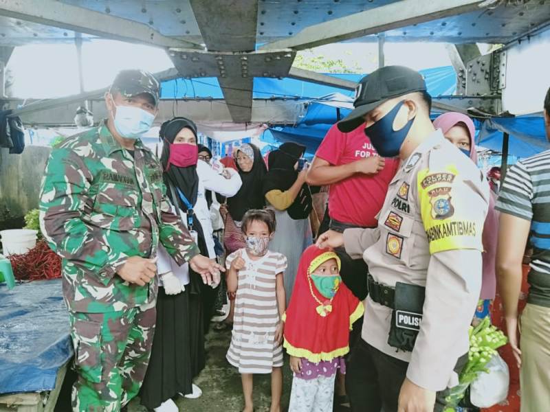 Bersama BKKBN Riau, Babinsa dan Bhabinkamtibmas Desa Teratak Buluh Bagikan Masker di Pasar