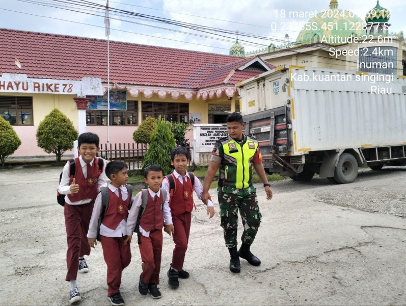 Babinsa Koramil 06 /Cerenti   Kodim 0302/ Inhu Pratu Chumaidi Menyeberangkan Anak-anak Sepulang Sekolah
