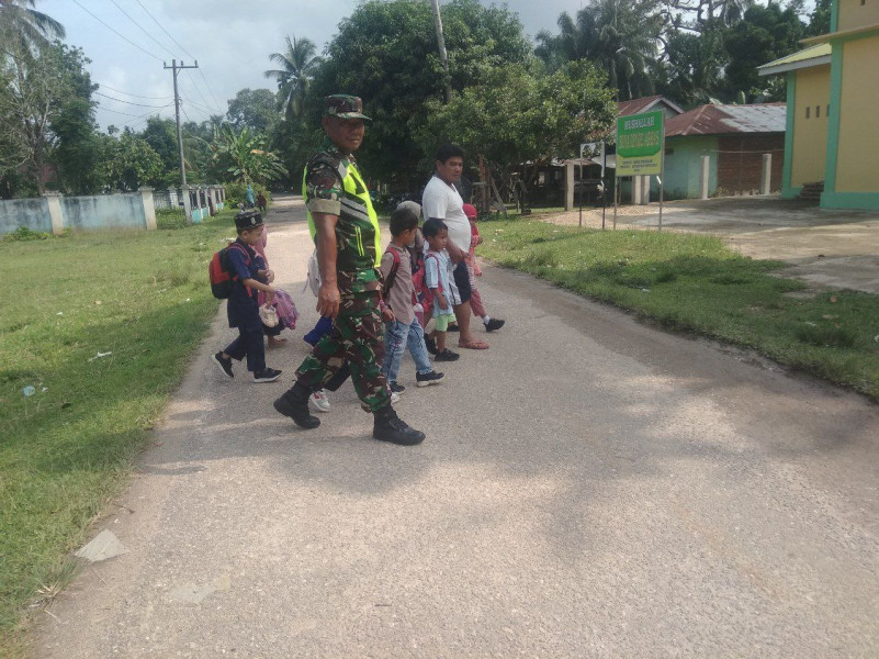 Babinsa Koramil 06/Cerenti Kodim 0302/Inhu Sertu Pirman Membantu Anak-anak TK Menyeberang Jalan
