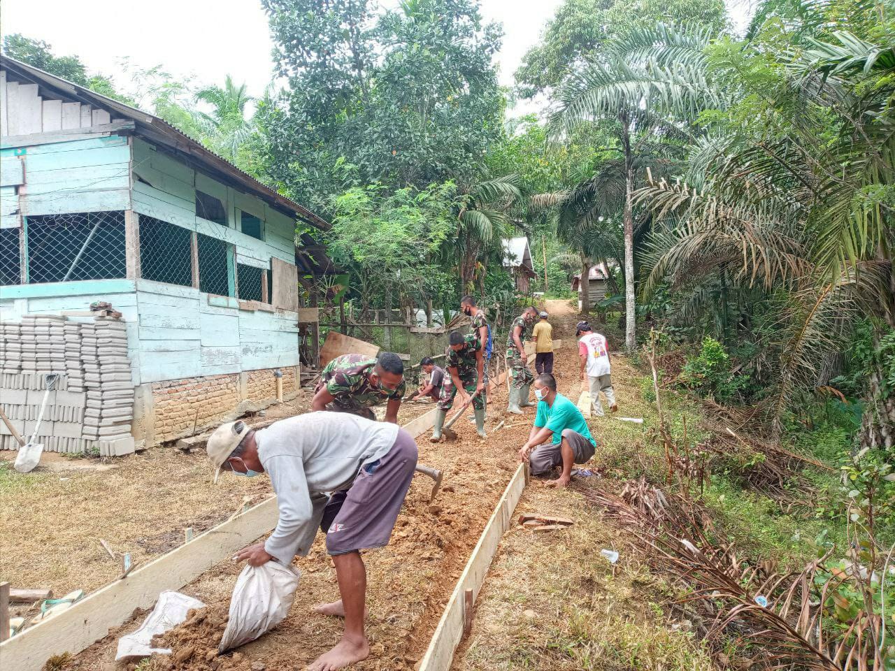 Cuaca Tak Menyurutkan Sinergitas Satgas TMMD Bersama Masyarakat Bangun Jalan