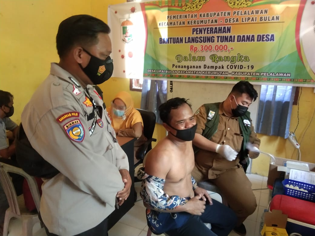 Bhabinkamtibmas Polsek Kerumutan Bersama Babinsa Dampingi Vaksinasi Covid-19